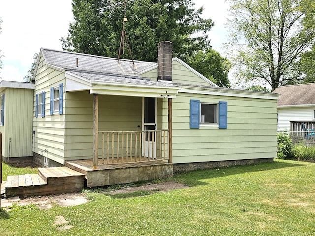 109 W Woodrow St, Fremont, MI 49412 - view of front of house with a front lawn, a chimney, and a shingled roof