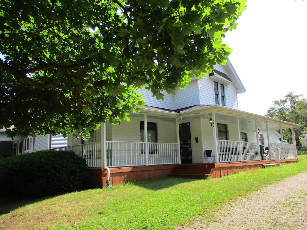 322 Main St, Perry, MI 48872 - view of front facade with a porch and a front lawn