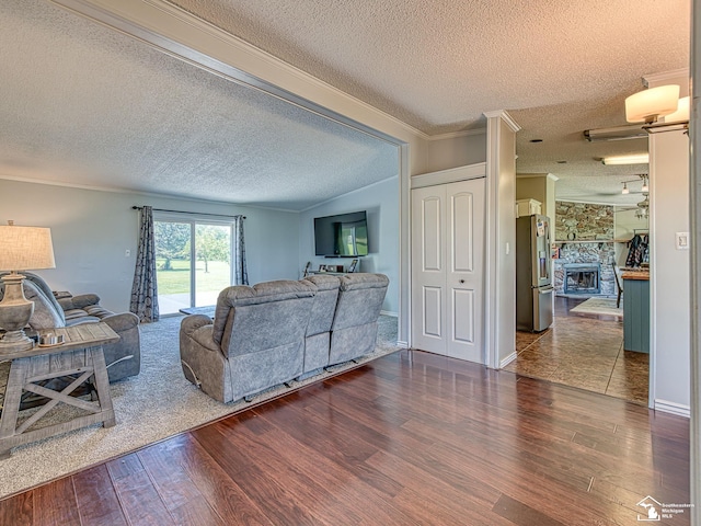 8955 Grafton Rd, Newport, MI 48166 - living area featuring a textured ceiling, dark wood-style floors, crown molding, and a stone fireplace