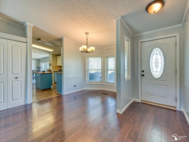 8955 Grafton Rd, Newport, MI 48166 - foyer featuring a textured ceiling, a chandelier, healthy amount of natural light, dark wood-type flooring, and ornamental molding