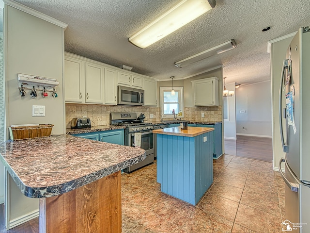 8955 Grafton Rd, Newport, MI 48166 - kitchen with appliances with stainless steel finishes, butcher block countertops, a peninsula, a textured ceiling, and tasteful backsplash