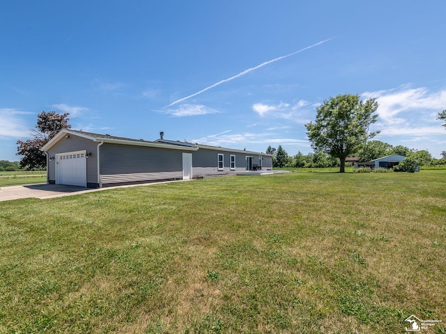 8955 Grafton Rd, Newport, MI 48166 - view of grassy yard featuring an attached garage and driveway