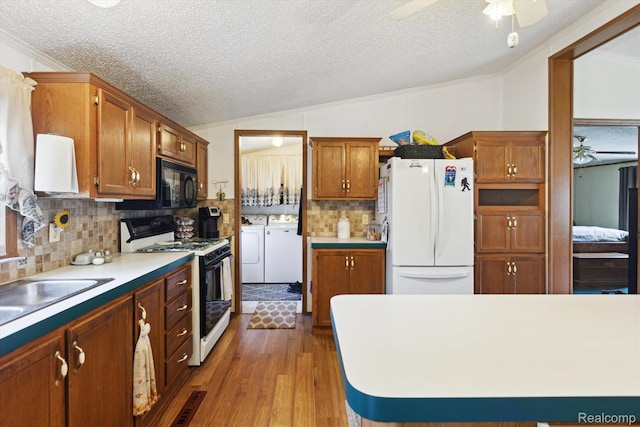 4591 Swaffer Rd, Millington, MI 48746 - kitchen with white appliances, independent washer and dryer, lofted ceiling, ceiling fan, and a textured ceiling