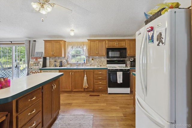4591 Swaffer Rd, Millington, MI 48746 - kitchen featuring white appliances, healthy amount of natural light, a textured ceiling, light wood-style flooring, and tasteful backsplash