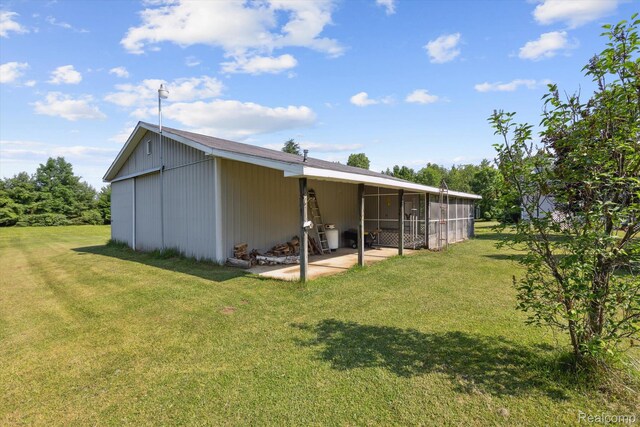 4591 Swaffer Rd, Millington, MI 48746 - rear view of house featuring a yard, a sunroom, and a patio area