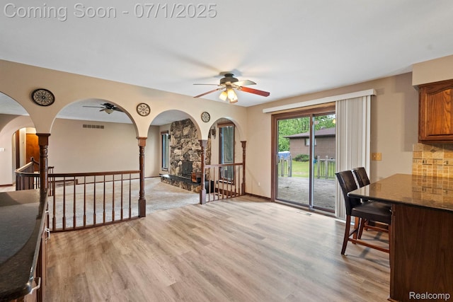 945 E Gunn Rd, Rochester, MI 48306 - dining area with a ceiling fan, light wood-type flooring, arched walkways, and a fireplace