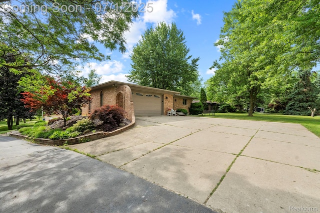 945 E Gunn Rd, Rochester, MI 48306 - view of home's exterior with brick siding, an attached garage, driveway, and a yard