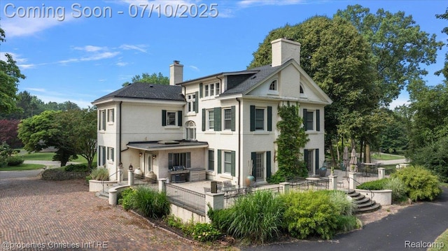 777 Kensington Ln, Bloomfield Hills, MI 48304 - rear view of property featuring a chimney, stucco siding, and a patio area