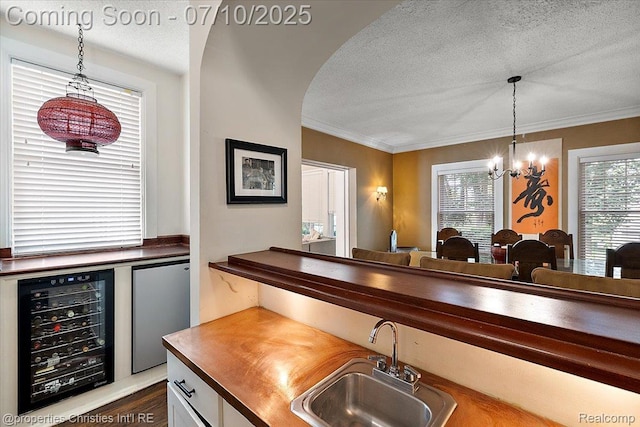 777 Kensington Ln, Bloomfield Hills, MI 48304 - indoor bar featuring wine cooler, a chandelier, a textured ceiling, fridge, and pendant lighting