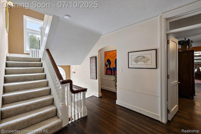 777 Kensington Ln, Bloomfield Hills, MI 48304 - stairs with a textured ceiling, arched walkways, wood finished floors, and vaulted ceiling