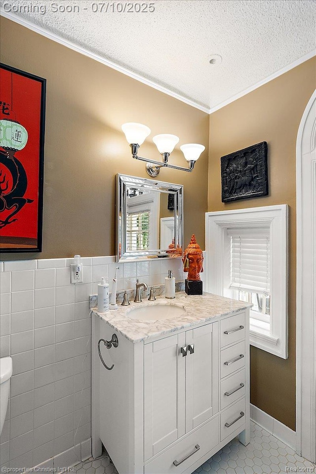 777 Kensington Ln, Bloomfield Hills, MI 48304 - bathroom featuring crown molding, a textured ceiling, vanity, tile patterned floors, and tile walls