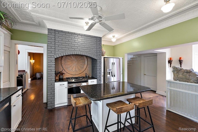 777 Kensington Ln, Bloomfield Hills, MI 48304 - kitchen with stainless steel appliances, crown molding, a ceiling fan, a breakfast bar, and white cabinetry