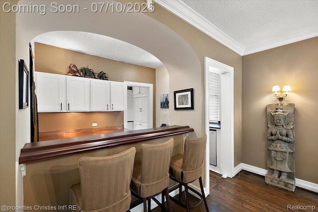 777 Kensington Ln, Bloomfield Hills, MI 48304 - bar featuring arched walkways, dark wood-type flooring, a textured ceiling, and ornamental molding