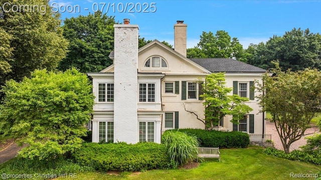 777 Kensington Ln, Bloomfield Hills, MI 48304 - back of property with stucco siding, a chimney, and a yard