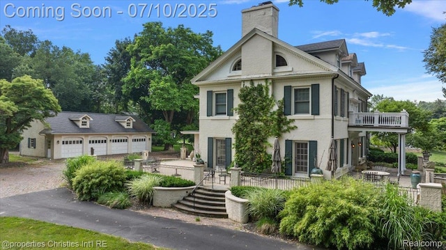 777 Kensington Ln, Bloomfield Hills, MI 48304 - view of front of home with a balcony, a chimney, stucco siding, a garage, and an outbuilding