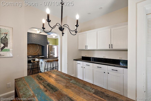 777 Kensington Ln, Bloomfield Hills, MI 48304 - kitchen with dark countertops, stainless steel fridge with ice dispenser, white cabinetry, and arched walkways