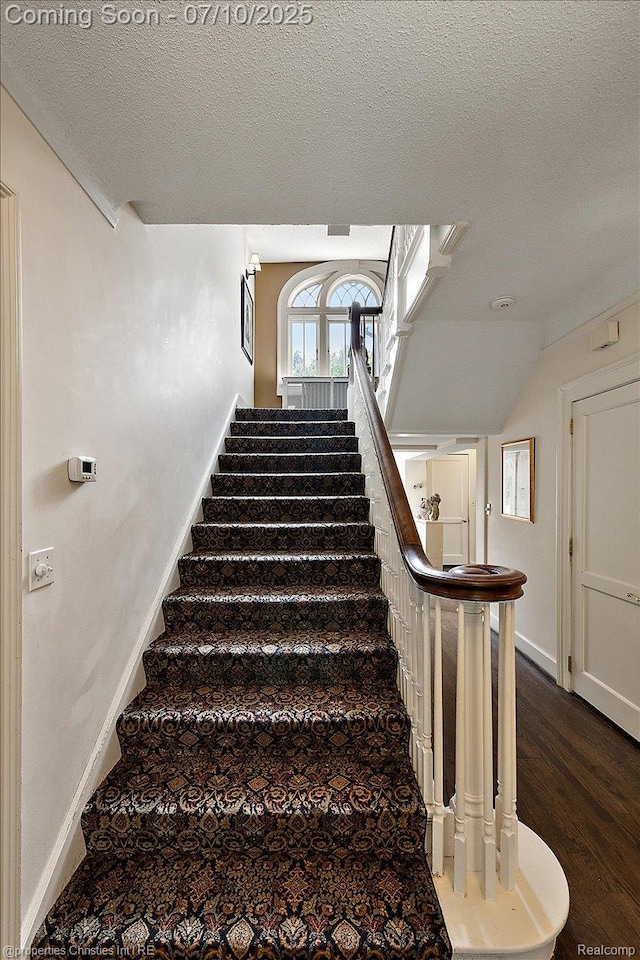 777 Kensington Ln, Bloomfield Hills, MI 48304 - stairway with a textured ceiling, wood finished floors, and vaulted ceiling