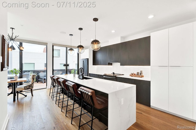 258 Edmund Pl, Detroit, MI 48201 - kitchen featuring modern cabinets, decorative backsplash, freestanding refrigerator, light wood-style flooring, and recessed lighting