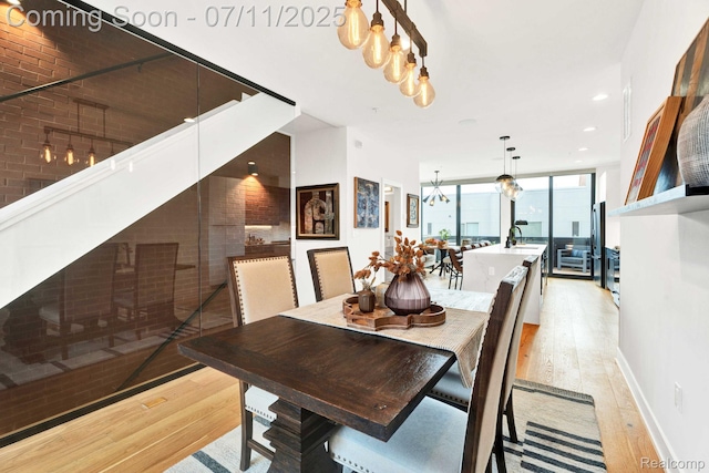 258 Edmund Pl, Detroit, MI 48201 - dining space featuring a chandelier, light wood-style floors, a wall of windows, and recessed lighting