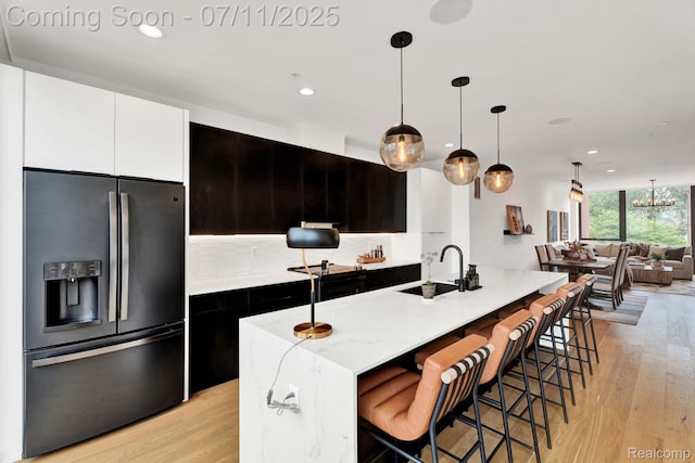 258 Edmund Pl, Detroit, MI 48201 - kitchen with refrigerator with ice dispenser, light wood-style flooring, decorative backsplash, recessed lighting, and white cabinets