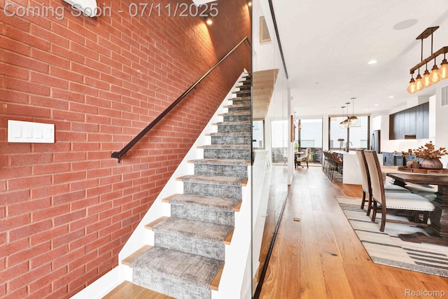 258 Edmund Pl, Detroit, MI 48201 - stairway with hardwood / wood-style flooring, brick wall, and recessed lighting