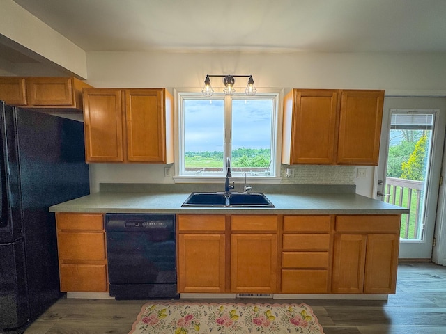 2620 N 184th Ave, Walkerville, MI 49459 - kitchen with black appliances, plenty of natural light, wood finished floors, and brown cabinetry