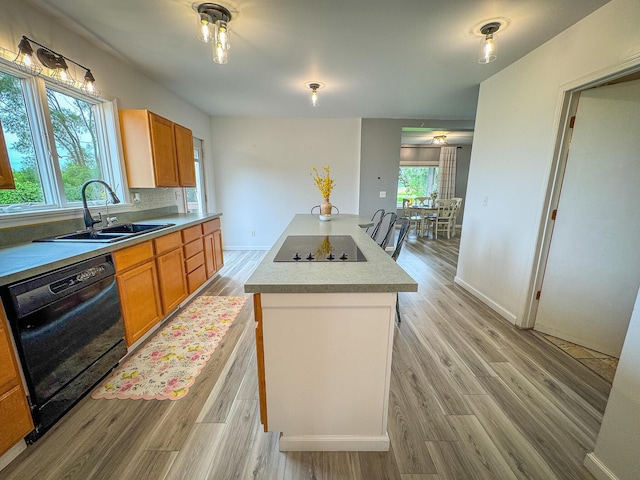 2620 N 184th Ave, Walkerville, MI 49459 - kitchen featuring black appliances, light wood-style flooring, a center island, light countertops, and brown cabinetry