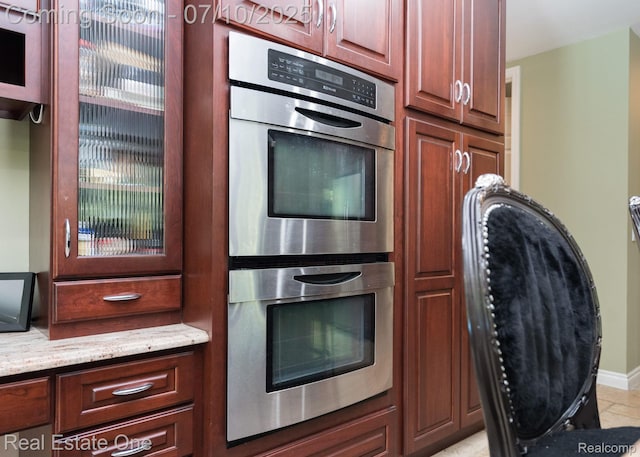 6120 Evanswood Rd, Troy, MI 48085 - kitchen featuring double oven, light stone counters, and glass insert cabinets