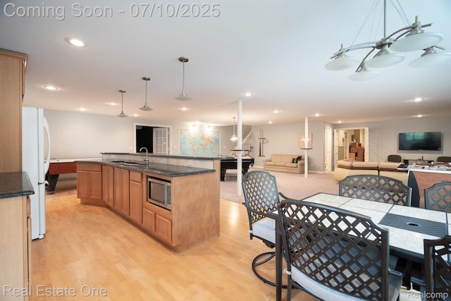 6120 Evanswood Rd, Troy, MI 48085 - kitchen featuring stainless steel microwave, freestanding refrigerator, light wood-type flooring, open floor plan, and recessed lighting