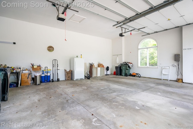 6120 Evanswood Rd, Troy, MI 48085 - garage with a garage door opener and freestanding refrigerator
