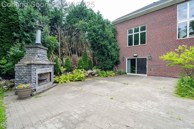 6120 Evanswood Rd, Troy, MI 48085 - view of patio / terrace with an outdoor stone fireplace and a detached garage