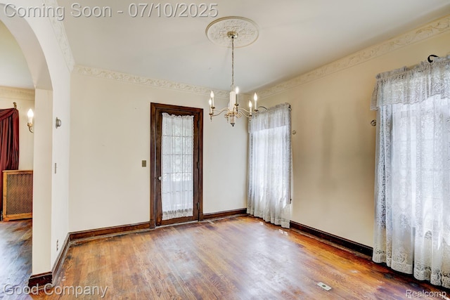 66 Oakdale Blvd, Pleasant Ridge, MI 48069 - empty room featuring wood finished floors, arched walkways, and a chandelier