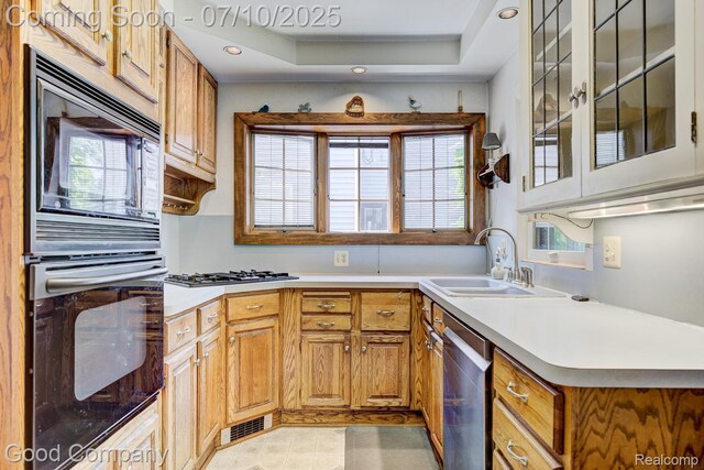 66 Oakdale Blvd, Pleasant Ridge, MI 48069 - kitchen with black appliances, recessed lighting, light countertops, glass insert cabinets, and a tray ceiling