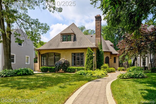 66 Oakdale Blvd, Pleasant Ridge, MI 48069 - view of front of property with a front lawn, stucco siding, a chimney, and roof with shingles
