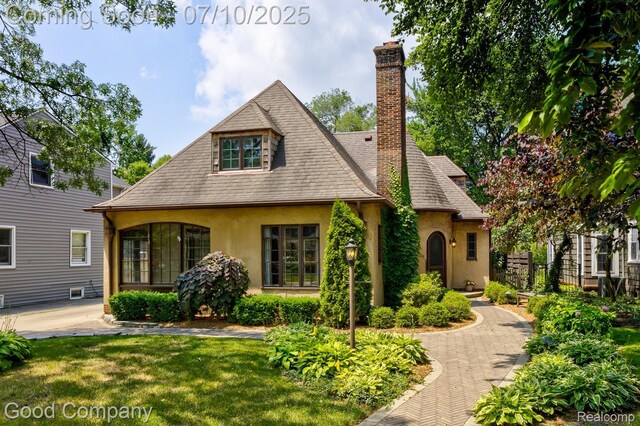 66 Oakdale Blvd, Pleasant Ridge, MI 48069 - view of front of house with stucco siding, a chimney, and a front lawn