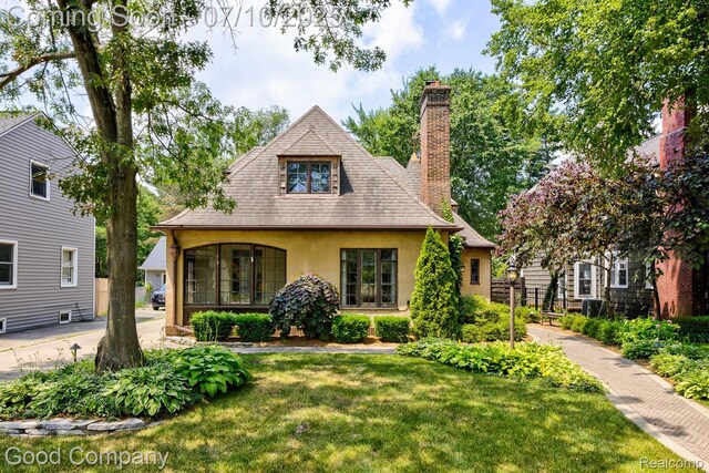 66 Oakdale Blvd, Pleasant Ridge, MI 48069 - view of front facade with stucco siding, a front lawn, and a chimney