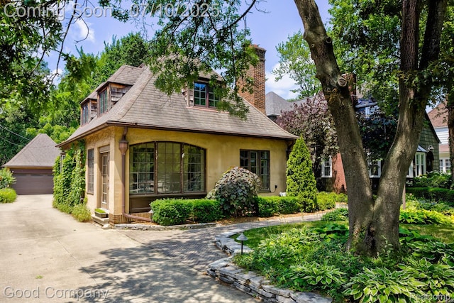 66 Oakdale Blvd, Pleasant Ridge, MI 48069 - view of front facade featuring stucco siding, a chimney, an outdoor structure, and a detached garage