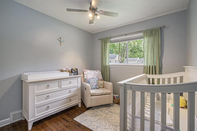 646 Dellwood Dr, Ann Arbor, MI 48103 - bedroom with dark wood-style flooring, a crib, and a ceiling fan