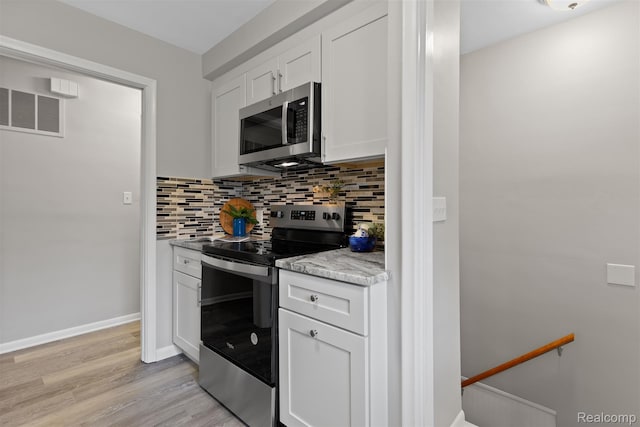24371 Grove Ave, Eastpointe, MI 48021 - kitchen with appliances with stainless steel finishes, tasteful backsplash, white cabinets, light wood-type flooring, and light countertops