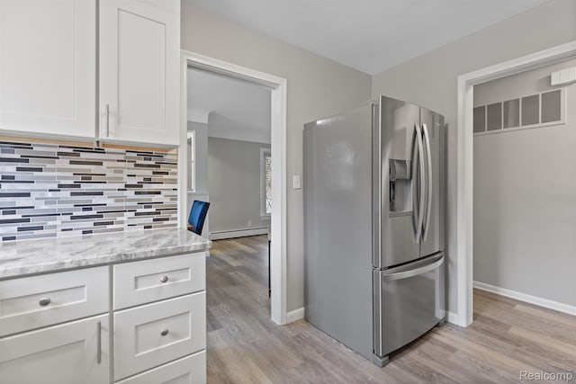 24371 Grove Ave, Eastpointe, MI 48021 - kitchen featuring stainless steel fridge with ice dispenser, light wood-style floors, tasteful backsplash, and white cabinets