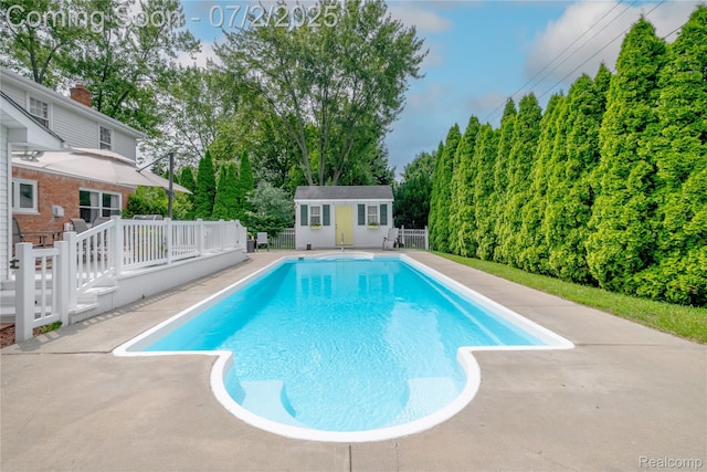 11216 Old Bridge Rd, Grand Blanc, MI 48439 - outdoor pool with an outdoor structure, a deck, view of wooded area, and a patio area