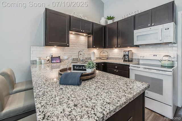 2489 Hatchery Crossing Dr, Waterford, MI 48329 - kitchen featuring white appliances, tasteful backsplash, light stone counters, and a peninsula