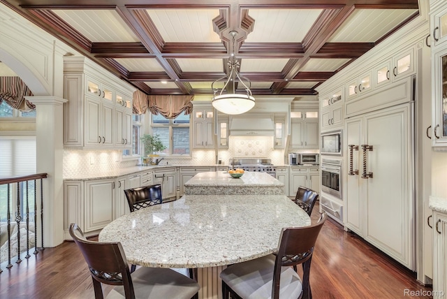 18198 Shelley Pond, Northville, MI 48168 - kitchen featuring a breakfast bar area, a kitchen island, dark wood-style floors, backsplash, and light stone countertops