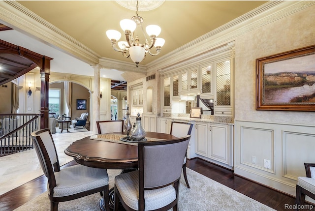 18198 Shelley Pond, Northville, MI 48168 - dining area featuring ornate columns, a decorative wall, a chandelier, crown molding, and dark wood-style floors