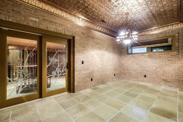 18198 Shelley Pond, Northville, MI 48168 - unfurnished dining area with brick wall, a chandelier, stone tile floors, and an ornate ceiling