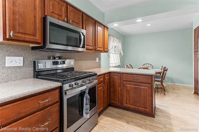 1306 Bishops Ter, Wixom, MI 48393 - kitchen with stainless steel appliances, light countertops, decorative backsplash, a peninsula, and recessed lighting