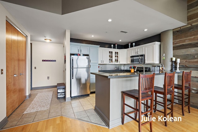 930 Washington Ave Unit 5C, Muskegon, MI 49441 - kitchen with appliances with stainless steel finishes, a peninsula, glass insert cabinets, white cabinets, and dark countertops