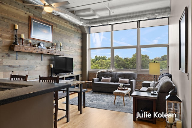 930 Washington Ave Unit 5C, Muskegon, MI 49441 - living area featuring wood walls, wood finished floors, and a ceiling fan