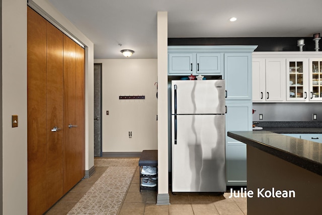 930 Washington Ave Unit 5C, Muskegon, MI 49441 - kitchen with freestanding refrigerator, glass insert cabinets, light tile patterned floors, white cabinetry, and recessed lighting