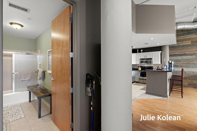 930 Washington Ave Unit 5C, Muskegon, MI 49441 - corridor with light tile patterned floors and wooden walls